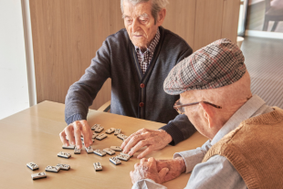 Dos persones grans jugant al domino